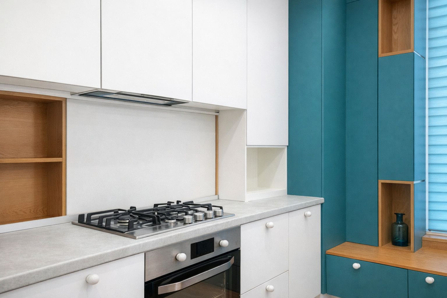 Vita köksknoppar i porslin på vita och blå skåp i ett modernt kök.