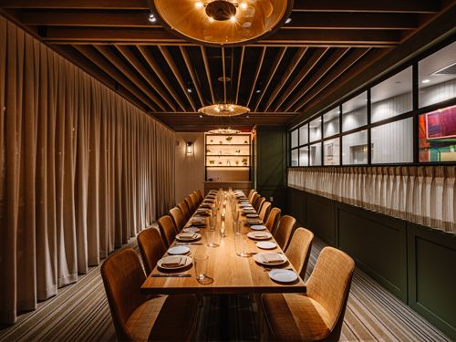 Exklusivt privat rum för att abonnera restaurang med långbord och varm belysning.